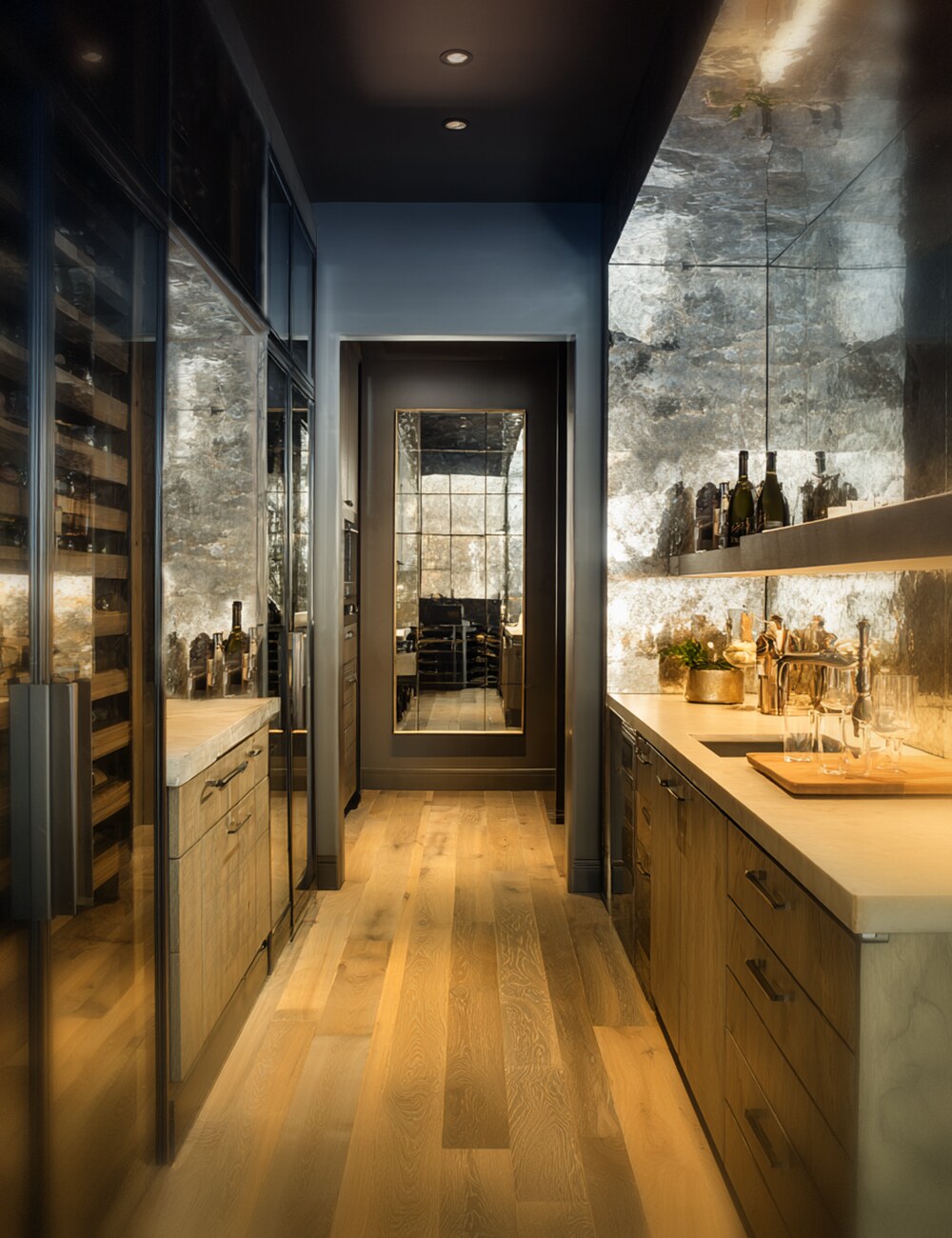 Antiqued mirror wine room with back-painted decorative glass walls, warm oak cabinetry, and brass details